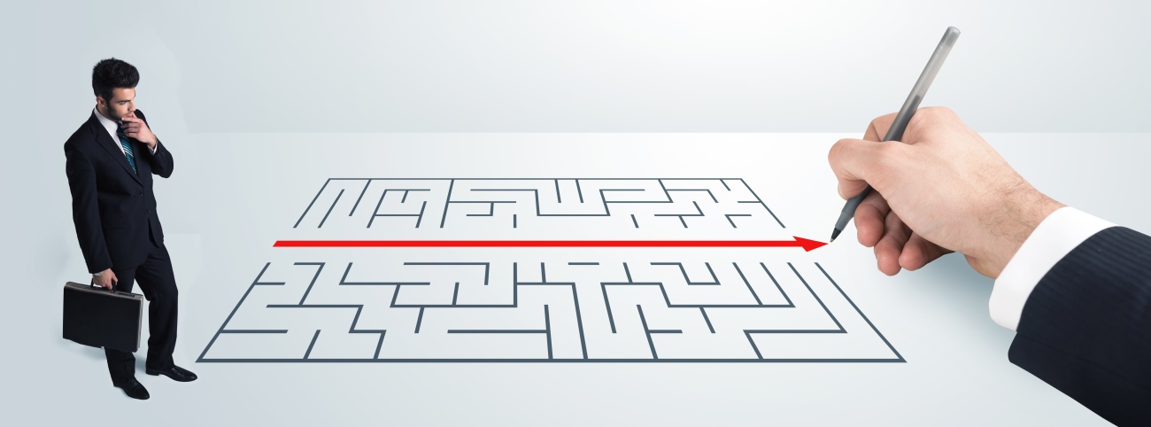 Business man looking at hand drawing solution for maze
